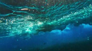 Maldivler 'deki dalgaların sualtı görüntüsü. Sörfçü suda boğuşuyor.