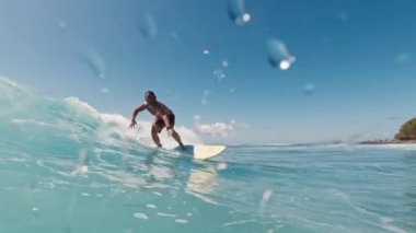 Okyanusta güçlü dalgalarda sörf yapan sörfçü yetenek ve heyecan sergiliyor. Maldivler