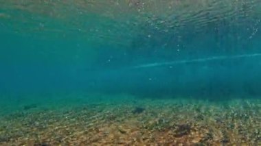 Yüzeyde oluşan ve kırılan bir dalganın sualtı görüntüsü. Maldivler