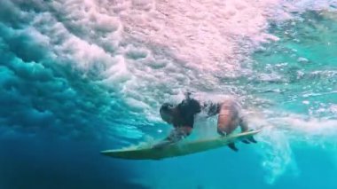 Sörfçü ördek dalışı yapar Dalganın altında sörf tahtası ile hile yapar