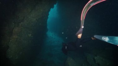 Freediver dar bir sualtı kanyonunda yüzüyor.