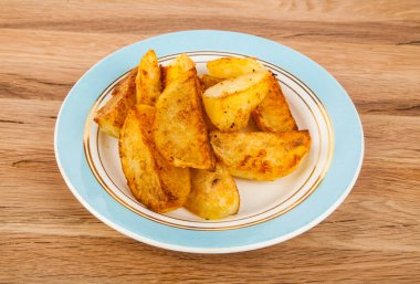 Ahşap arka planda bir tabakta patates kızartması. Tasarım ayrıntıları. Tasarım elemanları. Makro. Tam odaklanma. Kartvizitler, kartpostallar ve posterler için arka plan.