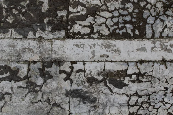 Old Plaster Wall With Dirty White Black Scratched Horizontal Background. Cracked concrete old wall texture background. Retro Vintage Worn Wall Wallpaper. Decayed Cracked Rough Abstract Banner Surface