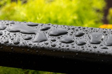 drops of water on dark water-repellent surface close-up as background for design with short focus. Beautiful abstract background of water drops on black. Non-wetting coating, water-repellent layer
