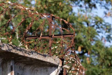Restricted area. Passage is prohibited closed. Border from old barbed metal barrier wire. Concept of border, prison, war, military base, refugees. Selective focus. As a conceptual modern background