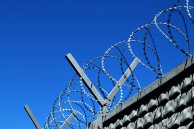Restricted area. Passage is prohibited closed. Border from old barbed metal barrier wire. Concept of border, prison, war, military base, refugees. Selective focus. As a conceptual modern background