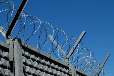 Restricted area. Passage is prohibited closed. Border from old barbed metal barrier wire. Concept of border, prison, war, military base, refugees. Selective focus. As a conceptual modern background