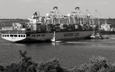 Odessa, Ukraine -2021: Logistics terminal shipment of import-export cargo containers on cargo ship in seaport. Industrial landscape with gantry cranes loading ship at piers of Odessa port, Yuzhny port