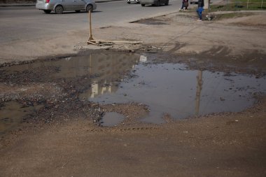 Due to the violation of road construction technology, severe frosts and heavy rains, the asphalt washed out the road and numerous cracks formed