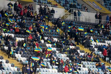 Odessa, Ukrayna - Kasım 2021: Ukrayna futbol taraftarları Ukrayna bayrakları ve ulusal özellikleriyle stadyumun tribünlerinde milli takımlarını coşkuyla destekliyorlar. Stadyumun tribünlerinde futbol taraftarları