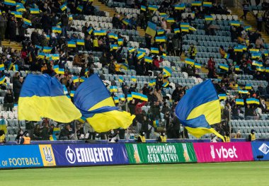 Odessa, Ukrayna - Kasım 2021: Ukrayna futbol taraftarları Ukrayna bayrakları ve ulusal özellikleriyle stadyumun tribünlerinde milli takımlarını coşkuyla destekliyorlar. Stadyumun tribünlerinde futbol taraftarları