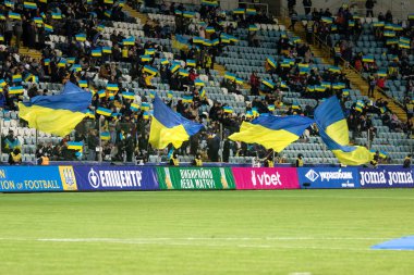 Odessa, Ukrayna - Kasım 2021: Ukrayna futbol taraftarları Ukrayna bayrakları ve ulusal özellikleriyle stadyumun tribünlerinde milli takımlarını coşkuyla destekliyorlar. Stadyumun tribünlerinde futbol taraftarları