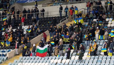 Odessa, Ukrayna - Kasım 2021: Ukrayna futbol taraftarları Ukrayna bayrakları ve ulusal özellikleriyle stadyumun tribünlerinde milli takımlarını coşkuyla destekliyorlar. Stadyumun tribünlerinde futbol taraftarları