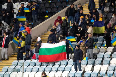 Odessa, Ukrayna - Kasım 2021: Ukrayna futbol taraftarları Ukrayna bayrakları ve ulusal özellikleriyle stadyumun tribünlerinde milli takımlarını coşkuyla destekliyorlar. Stadyumun tribünlerinde futbol taraftarları