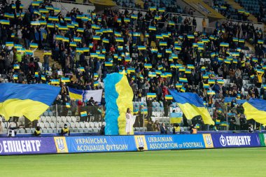 Odessa, Ukrayna - Kasım 2021: Ukrayna futbol taraftarları Ukrayna bayrakları ve ulusal özellikleriyle stadyumun tribünlerinde milli takımlarını coşkuyla destekliyorlar. Stadyumun tribünlerinde futbol taraftarları