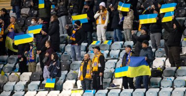 Odessa, Ukrayna - Kasım 2021: Ukrayna futbol taraftarları Ukrayna bayrakları ve ulusal özellikleriyle stadyumun tribünlerinde milli takımlarını coşkuyla destekliyorlar. Stadyumun tribünlerinde futbol taraftarları