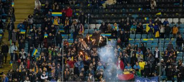 Odessa, Ukrayna - Kasım 2021: Ukrayna futbol taraftarları Ukrayna bayrakları ve ulusal özellikleriyle stadyumun tribünlerinde milli takımlarını coşkuyla destekliyorlar. Stadyumun tribünlerinde futbol taraftarları