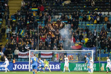 Odessa, Ukrayna - Kasım 2021: Ukrayna futbol taraftarları Ukrayna bayrakları ve ulusal özellikleriyle stadyumun tribünlerinde milli takımlarını coşkuyla destekliyorlar. Stadyumun tribünlerinde futbol taraftarları
