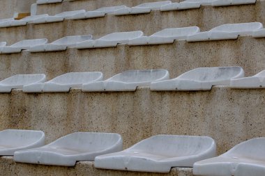 Küçük bir taşra stadyumundaki klasik spor arka koltukları. Futbol taraftarları için tribünlerin merdivenlerindeki boş koltukların arka planı