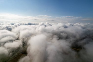 Bulutların üzerinde uçma atmosferi. Gök gürültülü bulutlar, bir hava aracının ufuk çizgisi. Tasarım için yaratıcı bir arka plan. Şafak, güneş bulutların üzerinde - olumlu seyahat konsepti Geleceğin meditasyon neşesi