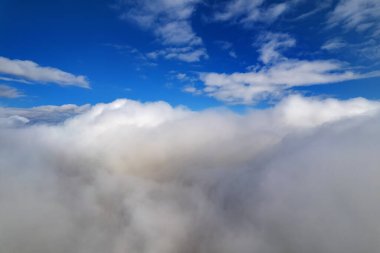 Bulutların üzerinde uçma atmosferi. Gök gürültülü bulutlar, bir hava aracının ufuk çizgisi. Tasarım için yaratıcı bir arka plan. Şafak, güneş bulutların üzerinde - olumlu seyahat konsepti Geleceğin meditasyon neşesi
