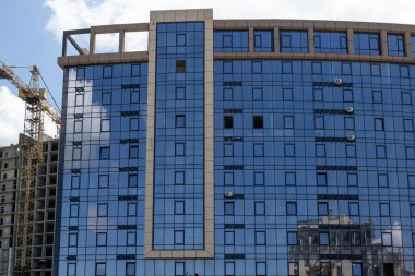 Modern bir gökdelen inşaatı. Emlak ve kurumsal yapı kavramı. İnşaat alanı. Modern inşaat mühendisliği, yeni tasarım ve yeni teknolojiler. Modern şehir manzarası