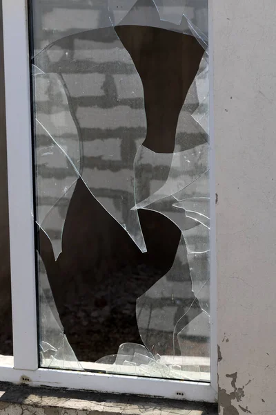 bullet hole in glass is a real bullet hole of a large caliber projectile bullet. Glass door pierced by a bullet during the war, terrorist attack. Broken glass with cracks and a large hole in glass