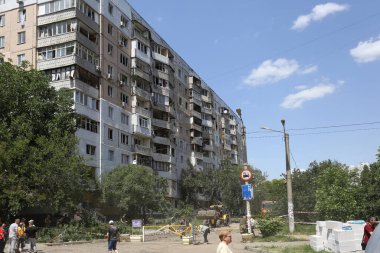 ODESSA, UKRAINE - 10 Haziran 2023 Ukrayna ve Rusya Savaşı. Bir top mermisi binanın avlusuna uçtu. Sivil evin oyun parkında roket patlaması sonucu hasar görmüş ön cephe ve kırık pencereler.