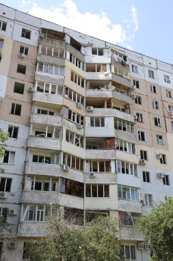 ODESSA, UKRAINE - 10 Haziran 2023 Ukrayna ve Rusya Savaşı. Bir top mermisi binanın avlusuna uçtu. Sivil evin oyun parkında roket patlaması sonucu hasar görmüş ön cephe ve kırık pencereler.