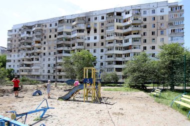 ODESSA, UKRAINE - 10 Haziran 2023 Ukrayna ve Rusya Savaşı. Bir top mermisi binanın avlusuna uçtu. Sivil evin oyun parkında roket patlaması sonucu hasar görmüş ön cephe ve kırık pencereler.