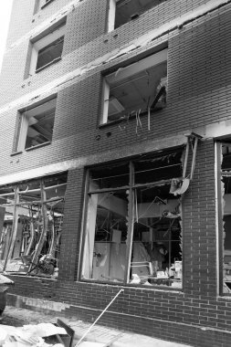 Bomba patlaması sonucu sivil bir binanın camları kırılmış. Cam parçaları pencerenin çerçevesinde tehlikeli bir şekilde duruyor. Ukrayna ve Rusya arasındaki savaş. Patlama ve roket parçalarıyla kırılan sivil pencereler