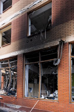 Bomba patlaması sonucu sivil bir binanın camları kırılmış. Cam parçaları pencerenin çerçevesinde tehlikeli bir şekilde duruyor. Ukrayna ve Rusya arasındaki savaş. Patlama ve roket parçalarıyla kırılan sivil pencereler