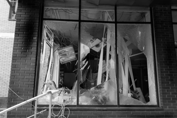 stock image Broken windows of civilian building of bomb explosion. Shards of glass stick out dangerously in window frame. War between Ukraine and Russia. Broken civilian windows by explosion and rocket fragments