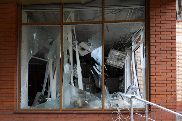 stock image Broken windows of civilian building of bomb explosion. Shards of glass stick out dangerously in window frame. War between Ukraine and Russia. Broken civilian windows by explosion and rocket fragments