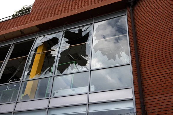 Stock image Broken windows of civilian building of bomb explosion. Shards of glass stick out dangerously in window frame. War between Ukraine and Russia. Broken civilian windows by explosion and rocket fragments