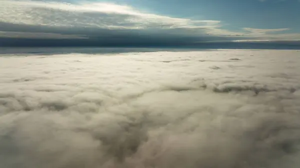 CFlying high above the clouds. Aerial view of clouds and horizon from drone. Thunderclouds from above before rain. Tragic gloomy natural landscape of horihonta at bird\'s eye view