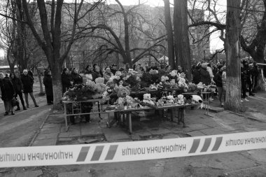 ODESSA, UKRAINE - 3 Mart 2024 Ukrayna Savaşı. Çiçekler, çocuk oyuncakları, mumlar, Rus füzesi tarafından yıkılan bir binanın yakınındaki lambalar. Siviller öldürüldü. Düzinelerce ölü ve yaralı.