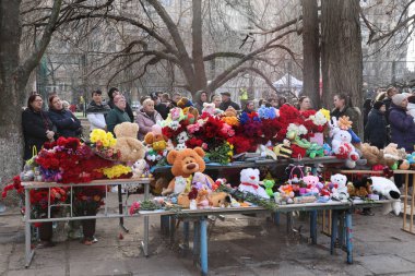 ODESSA, UKRAINE - 3 Mart 2024 Ukrayna Savaşı. Çiçekler, çocuk oyuncakları, mumlar, Rus füzesi tarafından yıkılan bir binanın yakınındaki lambalar. Siviller öldürüldü. Düzinelerce ölü ve yaralı.
