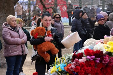 ODESSA, UKRAINE - 3 Mart 2024 Ukrayna Savaşı. Çiçekler, çocuk oyuncakları, mumlar, Rus füzesi tarafından yıkılan bir binanın yakınındaki lambalar. Siviller öldürüldü. Düzinelerce ölü ve yaralı.
