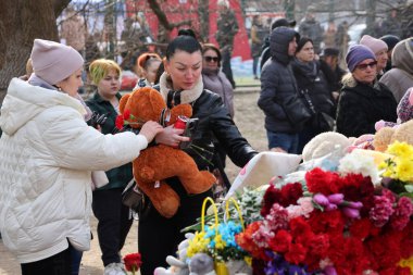 ODESSA, UKRAINE - 3 Mart 2024 Ukrayna Savaşı. Çiçekler, çocuk oyuncakları, mumlar, Rus füzesi tarafından yıkılan bir binanın yakınındaki lambalar. Siviller öldürüldü. Düzinelerce ölü ve yaralı.