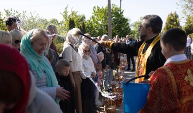 ODESSA, UKRAINE - 5 Mayıs 2024: Hıristiyan Ortodoks Kilisesi. Paskalya pastası, Paskalya, İsa 'nın dirilişi bayramında yumurtalar. Rahip, kilise cemaatini tatilde kutsal suyla kutsar.