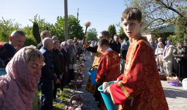 ODESSA, UKRAINE - 5 Mayıs 2024: Hıristiyan Ortodoks Kilisesi. Paskalya pastası, Paskalya, İsa 'nın dirilişi bayramında yumurtalar. Rahip, kilise cemaatini tatilde kutsal suyla kutsar.
