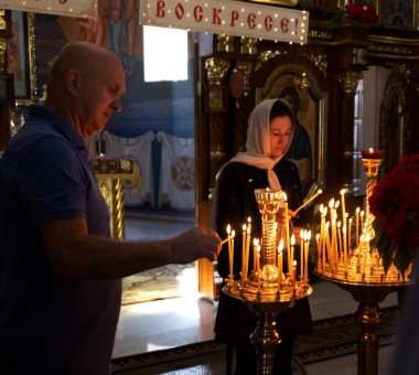 ODESSA, UKRAINE - 5 Mayıs 2024: Hıristiyan kilise cemaati Paskalya Bayramı 'nda kilisenin Diriliş Günü' nde kutsal azizlerin ikonunda mum yaktı
