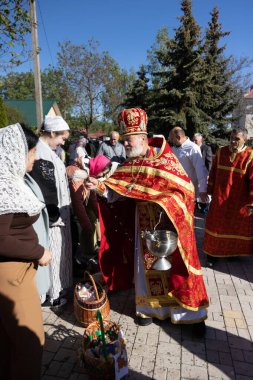 ODESSA, UKRAINE - 5 Mayıs 2024: Hıristiyan Ortodoks Kilisesi. Paskalya pastası, Paskalya, İsa 'nın dirilişi bayramında yumurtalar. Rahip, kilise cemaatini tatilde kutsal suyla kutsar.