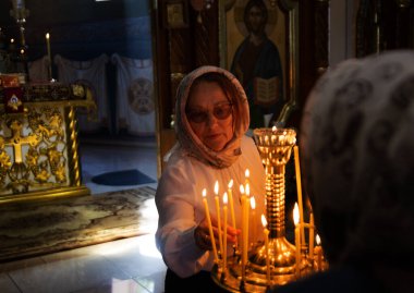 ODESSA, UKRAINE - 5 Mayıs 2024: Hıristiyan kilise cemaati Paskalya Bayramı 'nda kilisenin Diriliş Günü' nde kutsal azizlerin ikonunda mum yaktı