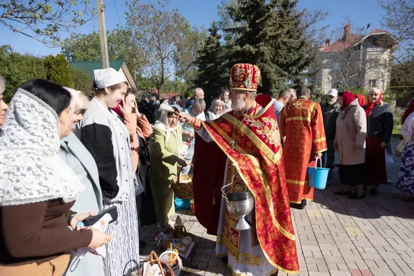 stock image ODESSA, UKRAINE -May 5, 2024: Christian Orthodox Church. Blessing of Easter cake, Easter, eggs on Easter holiday of Resurrection of Jesus Christ. Priest blesses parishioners with holy water on holiday