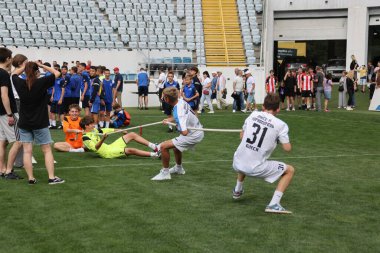 ODESSA, UKRAINE, 9 Haziran 2024: Çocuk takımları spor festivalinde çekişme oyunu oynuyorlar. Spor takımı kavgası. Stadyumun yeşil çimlerinde çekişme. Çocuk sporları. Sağlıklı yaşam tarzı, spor eğlencesi.