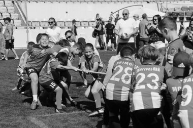 ODESSA, UKRAINE, 9 Haziran 2024: Çocuk takımları spor festivalinde çekişme oyunu oynuyorlar. Spor takımı kavgası. Stadyumun yeşil çimlerinde çekişme. Çocuk sporları. Sağlıklı yaşam tarzı, spor eğlencesi.