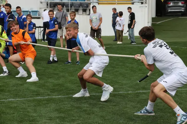 ODESSA, UKRAINE, 9 Haziran 2024: Çocuk takımları spor festivalinde çekişme oyunu oynuyorlar. Spor takımı kavgası. Stadyumun yeşil çimlerinde çekişme. Çocuk sporları. Sağlıklı yaşam tarzı, spor eğlencesi.