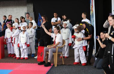 ODESSA, UKRAINE - 21 Eylül 2024: Çocuk ve gençlik sporları. Ukrayna Karate Kupası. Seyircilerin ebeveynleri destek grubuna koçluk yapıyor, sporcuları duygusal olarak destekliyor. Tribünlerdeki hayranlar karate